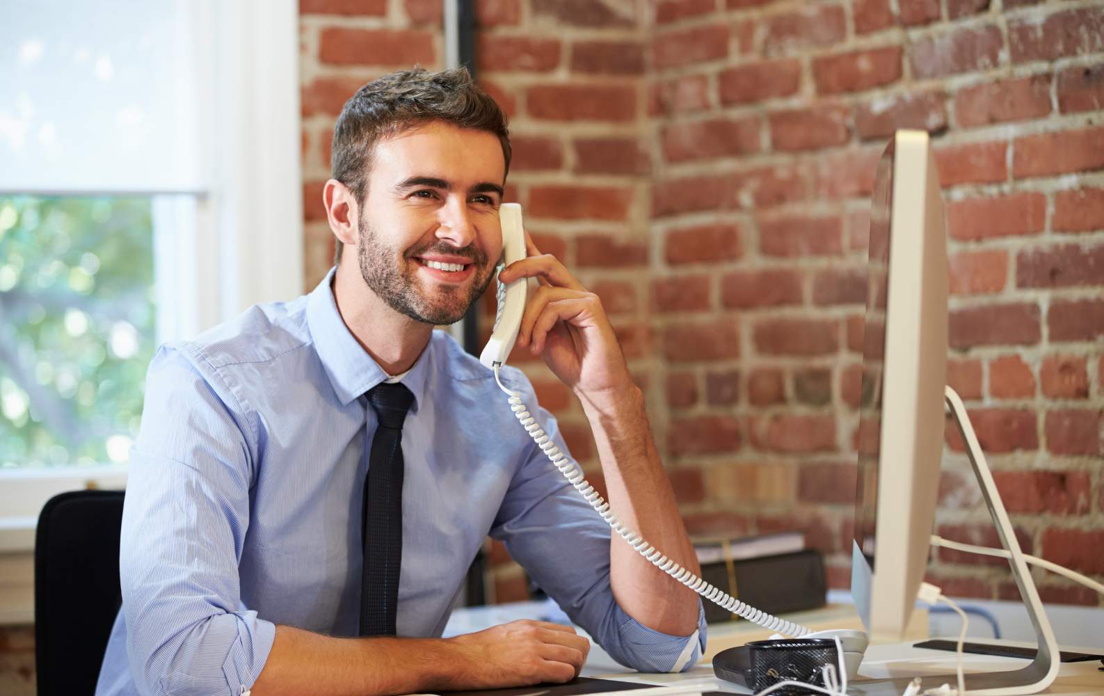 Man smiling on a call using ip phone
