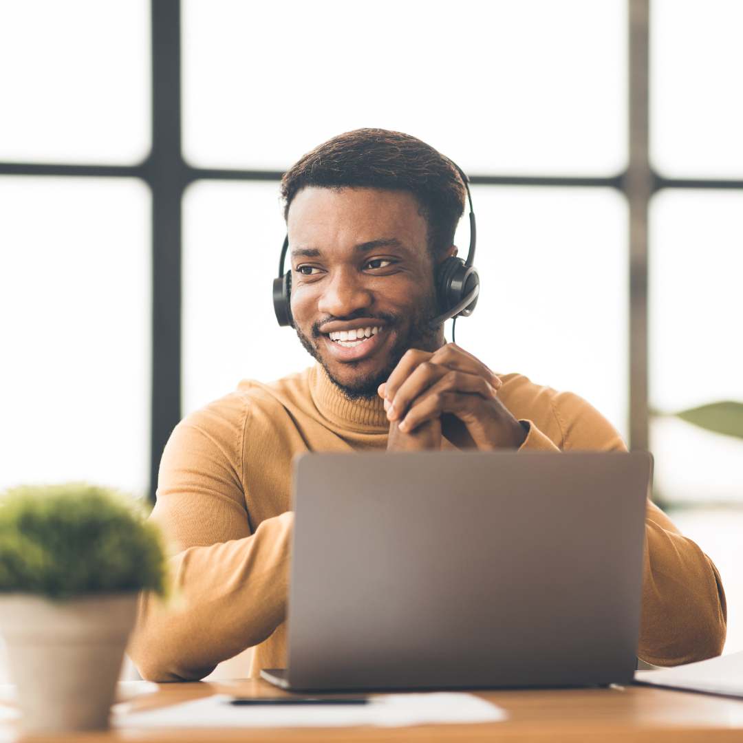 Man working on his laptop with a headset on