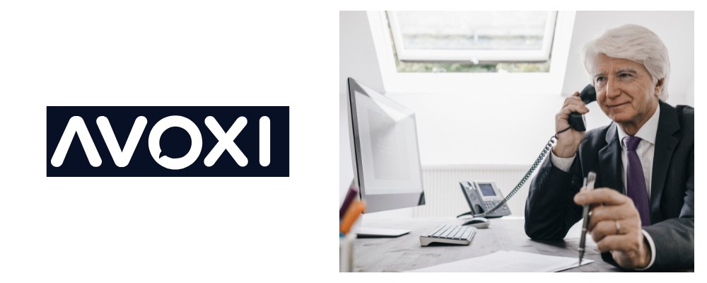 A mature AVOXI consultant in a suit using a SIP-enabled device