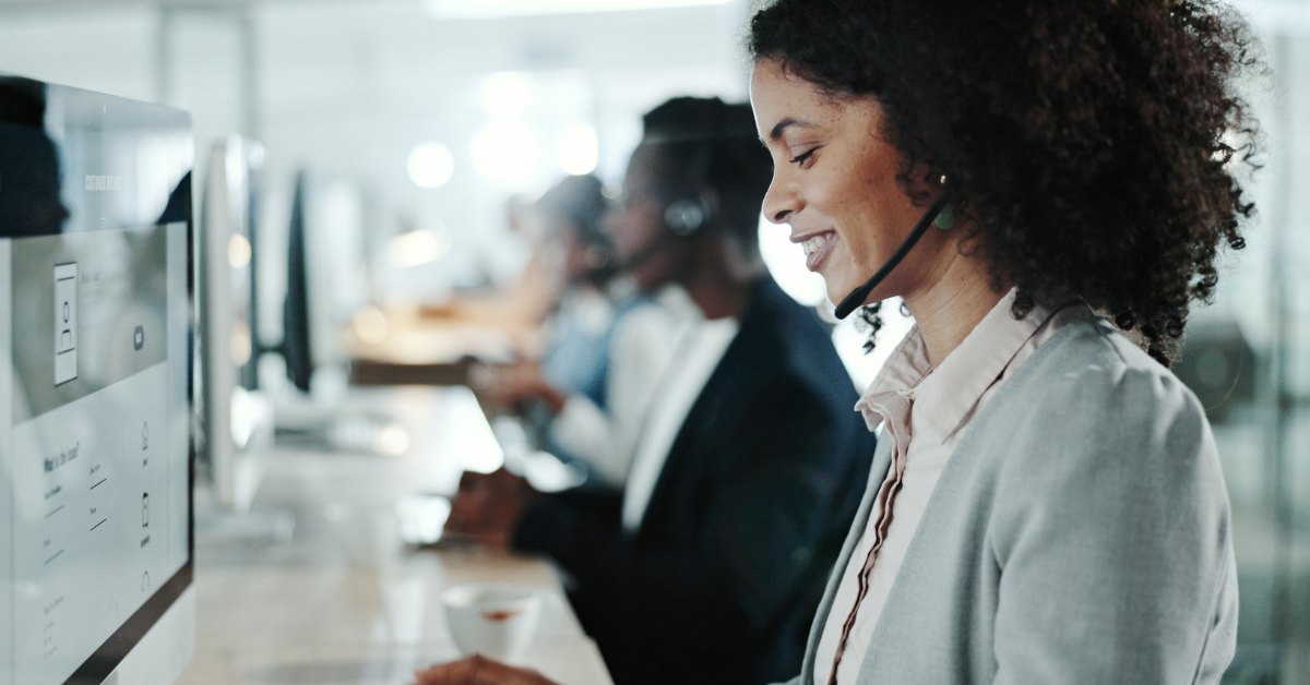 Call centre agent at her desk, speaking with a client, using a headset and cloud pbx call centre software