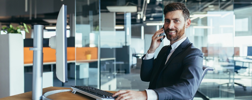 A businessman at his desk using a VoIP and internet fibre bundle to work