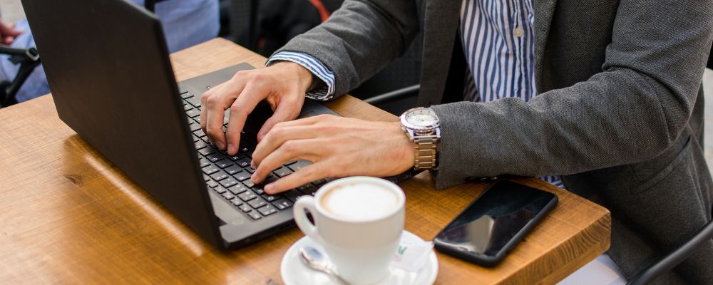 A businessman working in a café, representing the flexibility and continuity made possible with cloud PBX.