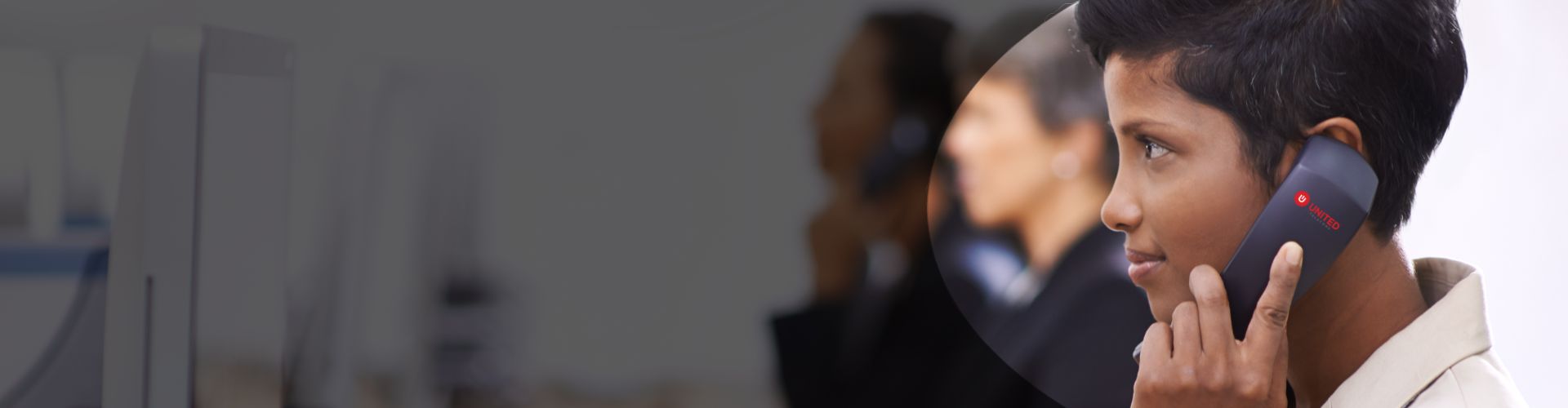 Side profile of a young women with a wireless VoIP phone handset to her ear
