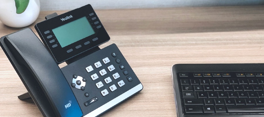 voip desk phone with tablet on desk