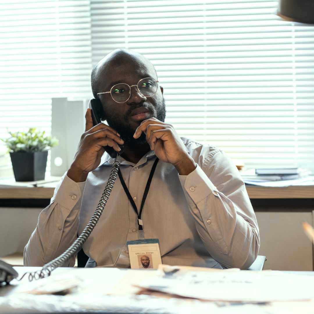 An education administration worker, at his desk, using a Snom phone