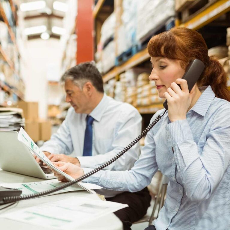 A warehouse logistics worker, at her desk, using a Snom phone