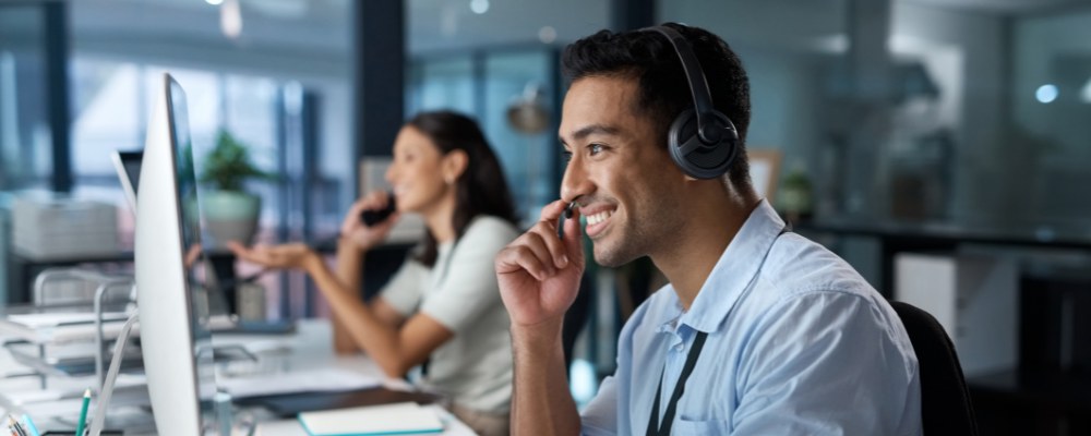 Call centre agent using a VoIP phone to chat with a customer.