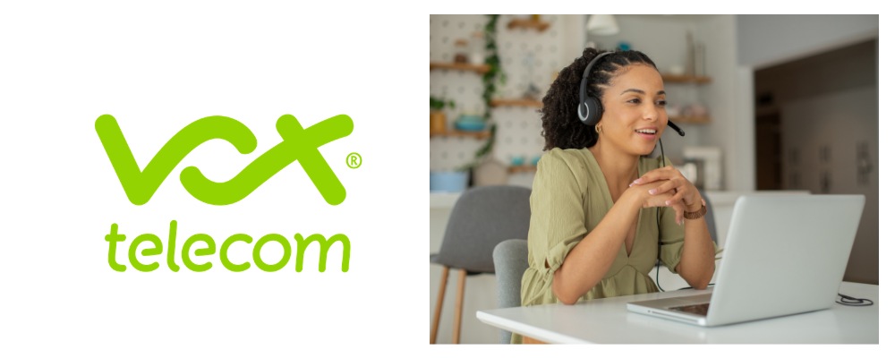 A Vox business fibre consultant wearing a green top and headset taking a client call