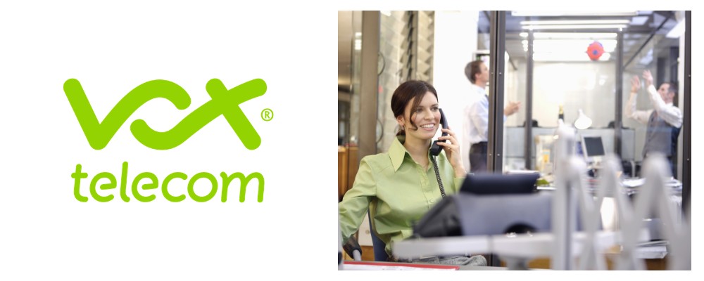 A Vox conlsutant in a green shirt using a SIP-enabled deskphone