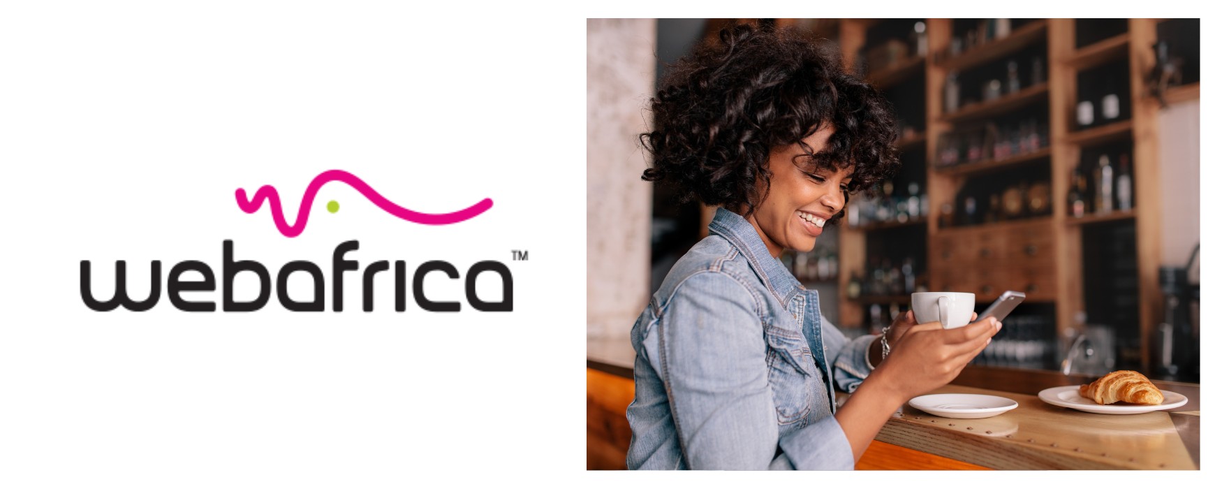 A woman smiling at her phone in a cafe